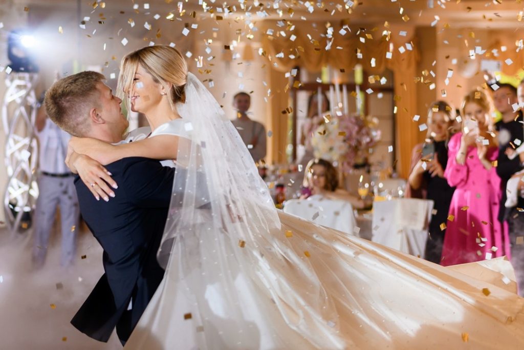 一對結婚的新人，在結婚典禮上擁抱著彼此，接受來自親朋好友的祝福