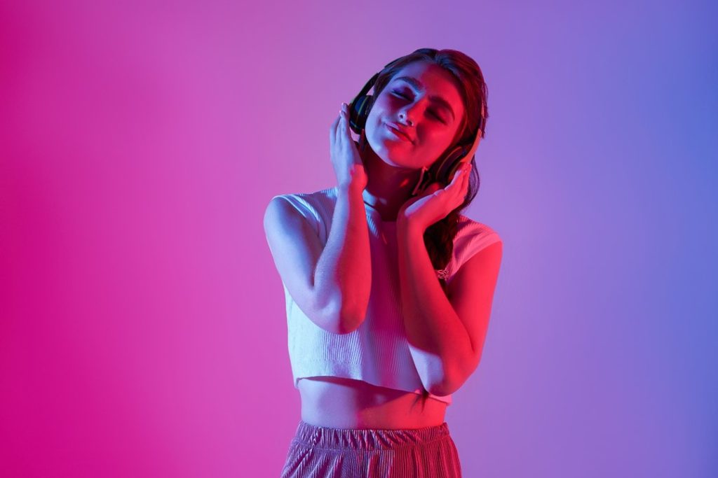 一位女生聽著耳機，陶醉在其中，顯示開場及結尾音樂的重要性